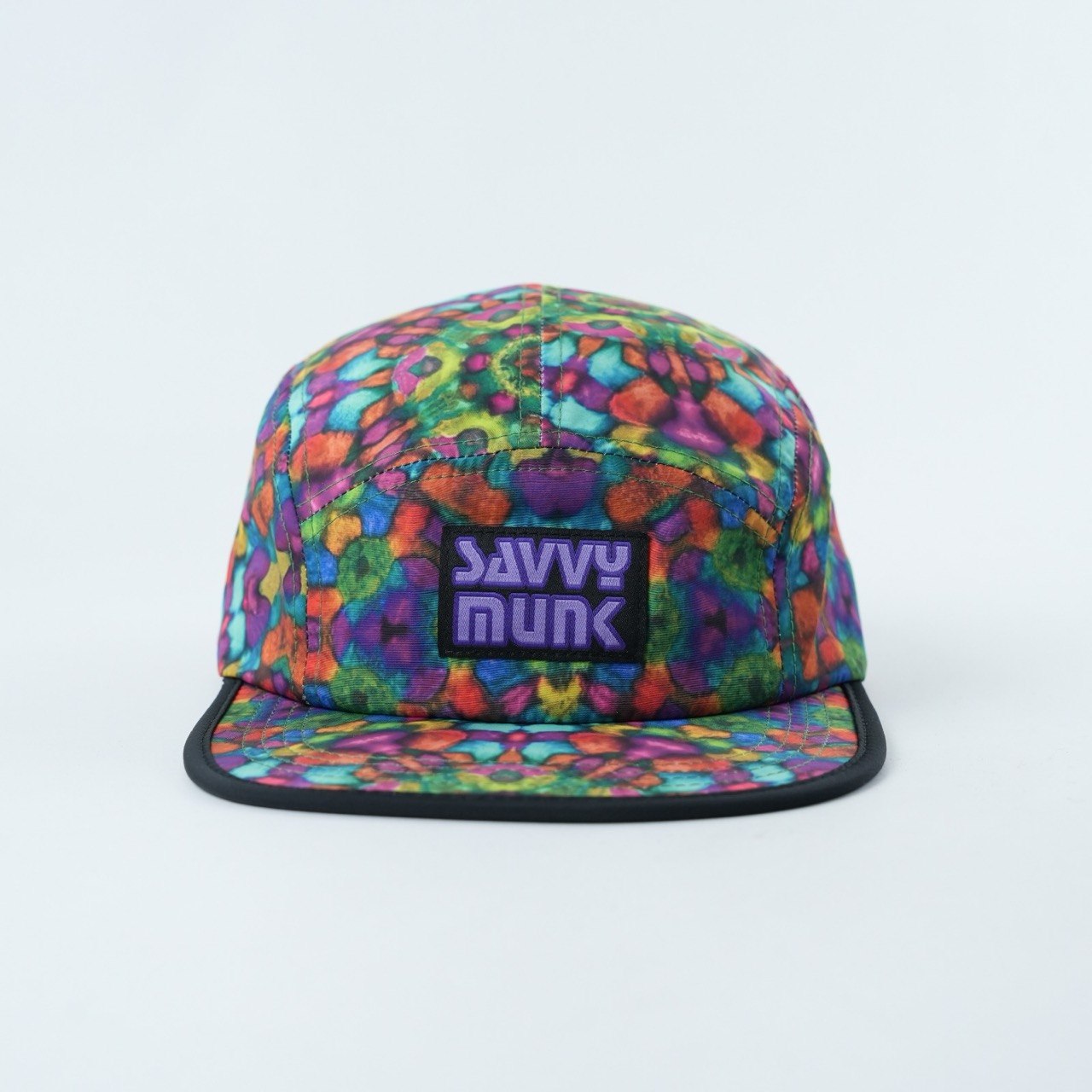 Savvy Munk Grass Water 5-Panel Hat featuring a colorful, high-energy kaleidoscopic print with an embroidered logo patch