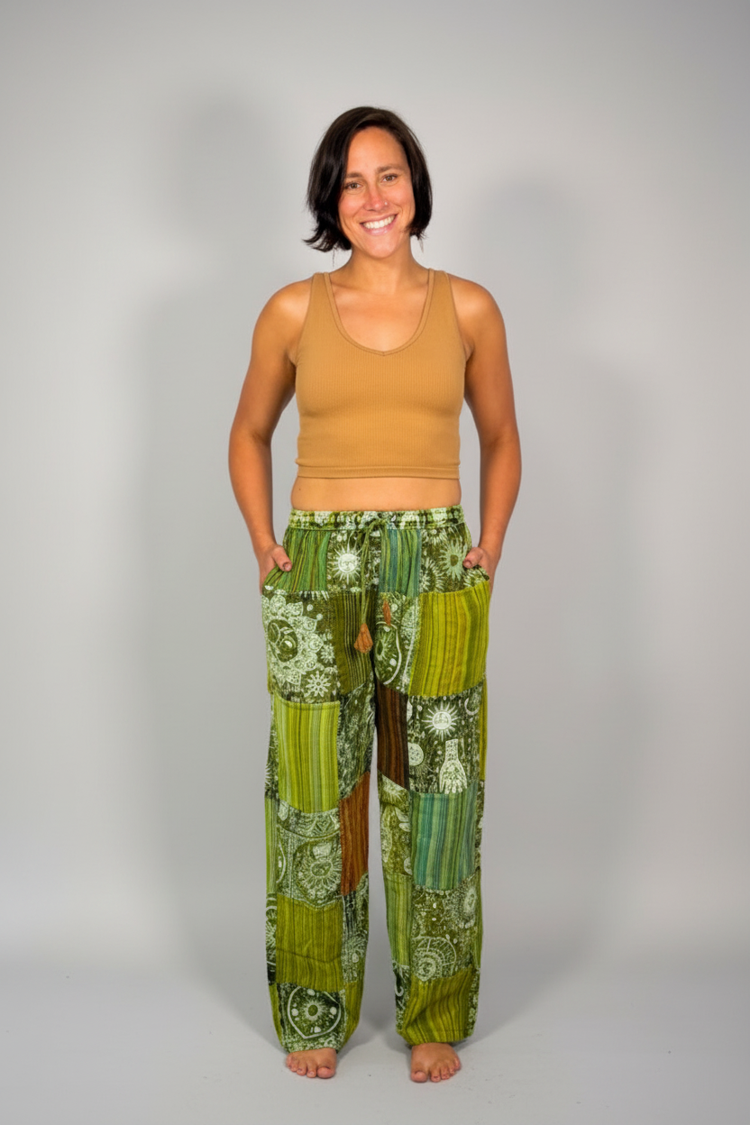 Model wearing the Savvy Munk Sage Sunburst Patchwork Drawstring Pants, showcasing the flowing silhouette, vibrant handcrafted patterns, and artisan cotton quality in a studio setting.