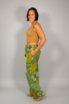 Savvy Munk model wearing Sage Sunburst Patchwork Drawstring Pants handcrafted in Nepal, paired with a tan crop top.