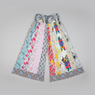 Savvy Munk Meadows of Nepal Palazzo Pants featuring colorful floral and batik patchwork patterns in a wide-leg flare silhouette.