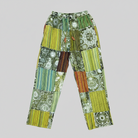 Savvy Munk Sage Sunburst Patchwork Drawstring Pants displayed flat, highlighting vibrant handcrafted batik, tie-dye, and patchwork patterns on 100% artisan cotton from Nepal.