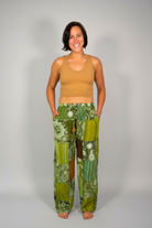 Model wearing the Savvy Munk Sage Sunburst Patchwork Drawstring Pants, showcasing the flowing silhouette, vibrant handcrafted patterns, and artisan cotton quality in a studio setting.
