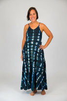 Model wearing the Savvy Munk Indigo Waves Hand-Dyed Tiered Maxi Dress, showcasing the flowing silhouette, vibrant handcrafted patterns, and artisan cotton quality in a studio setting.