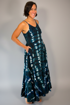 Model wearing the Savvy Munk Indigo Waves Hand-Dyed Tiered Maxi Dress, showcasing the flowing silhouette, vibrant handcrafted patterns, and artisan cotton quality in a studio setting.