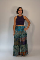 Model wearing the Savvy Munk Prism Flow Tiered Boho Maxi Skirt, showcasing the flowing silhouette, vibrant handcrafted patterns, and artisan cotton quality in a studio setting.